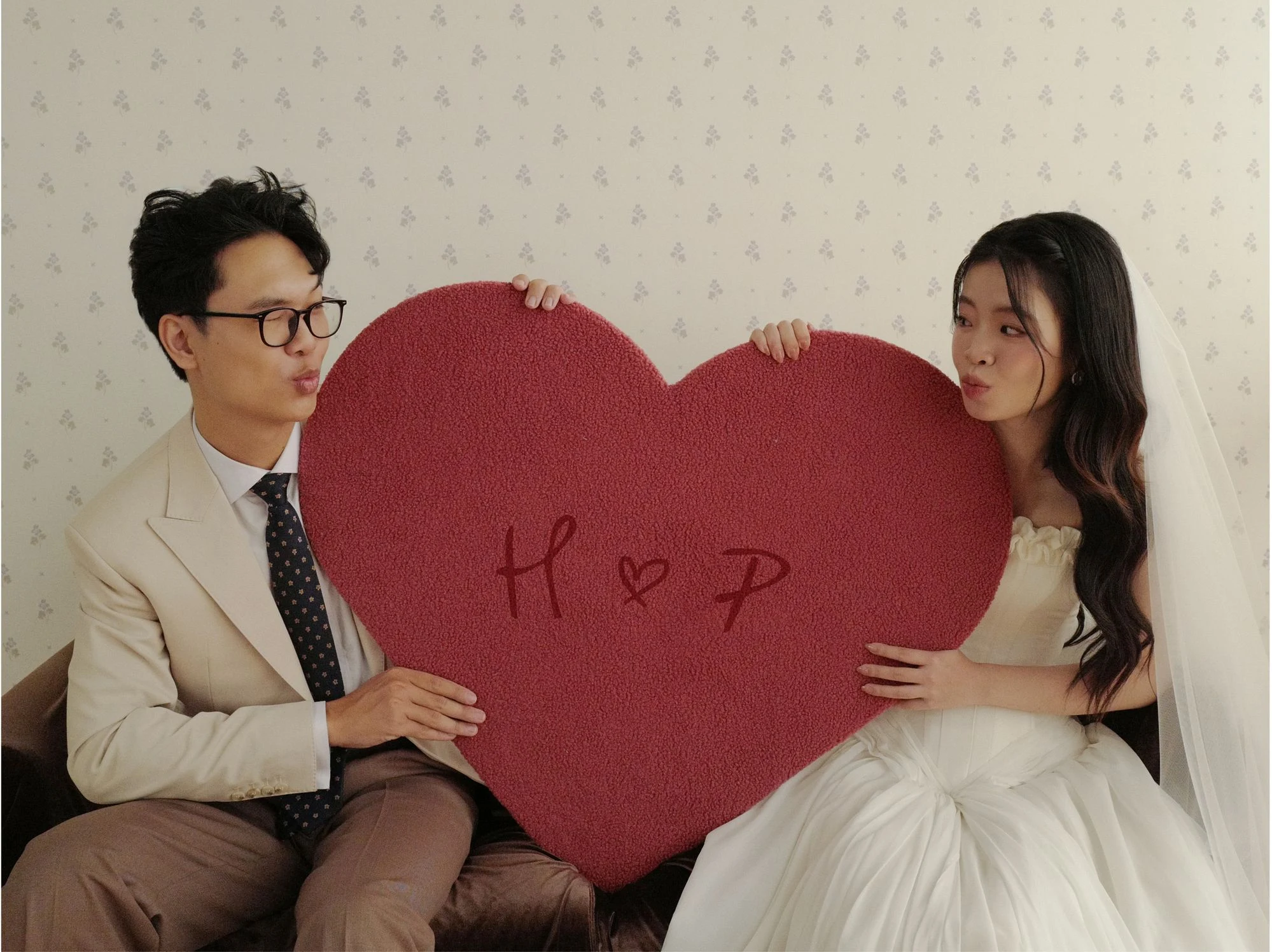 Hoàng và Phương cầm tấm bảng trái tim đỏ có chữ H ♡ P